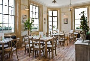 restauracja z drewnianymi stołami, krzesłami i oknami w obiekcie The Orange w Londynie