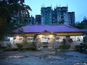 a building with a purple roof in front of a city at SHANKARDHABA&resort in Guwahati +1 photo