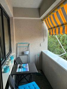 a small balcony with a table and a bath tub at Lazaro Urban Apartment in Skopje