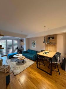 a living room with a blue couch and a table at Lazaro Urban Apartment in Skopje