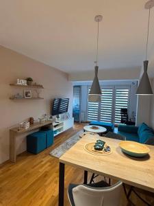 a living room with a table and a blue couch at Lazaro Urban Apartment in Skopje
