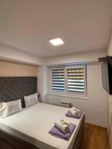 a bedroom with a large bed with towels on it at Lazaro Urban Apartment in Skopje