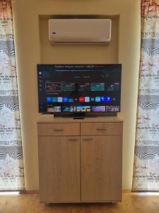 a large flat screen tv on a wall with a unit at Pylimo 59 in Šventoji +4 photos