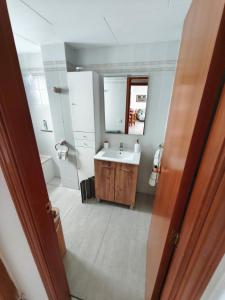 a bathroom with a sink and a mirror at Front beach apartment in Torreblanca +16 photos