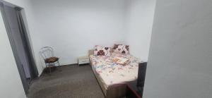 a small bed in a room with a chair at D&ATurism in Prăjila