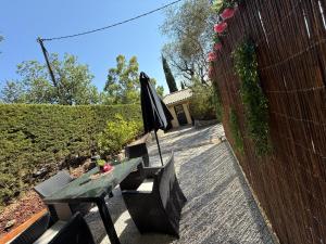 a table and chairs and an umbrella on a patio at Évasion au calme in Montauroux
