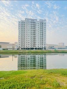 a tall building with a reflection in a body of water at جناح فاخر بإطلالة على البحيرة وجاكوزي خاص in Al Khobar