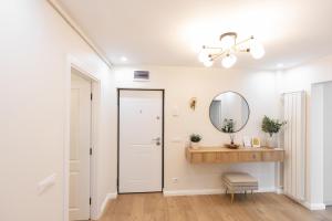 a white hallway with a mirror and a sink at A&K Apartament in Bacău +15 photos