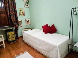 a bedroom with a bed with red pillows on it at Casa das Viagens in Ferreira do Alentejo +21 photos