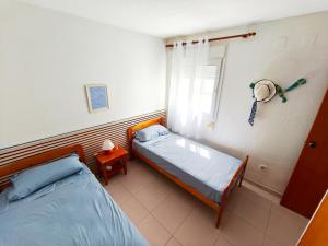 a bedroom with two beds and a window at Front beach apartment in Torreblanca