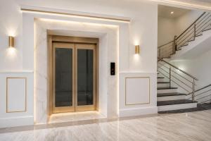 a hallway with a glass door and stairs at Hotel PKD Vrindavan Near 100 Futta Main Road in Vrindāvan