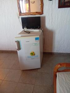 a small refrigerator with a mirror on top of it at Rizos Veranda - Rooms in Isómata