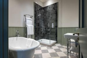 a bathroom with a tub and a shower and a sink at Dumbleton Hall in Broadway +62 photos