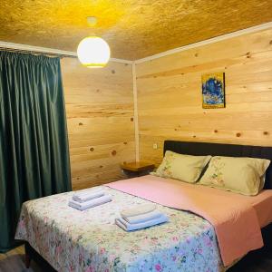 a bedroom with a bed with two towels on it at guesthouse NENO in Mestia