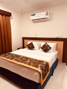 a bedroom with a large bed with avertisementatronatronstrationstrationstration at Britstar Suites Salalah in Salalah +44 photos