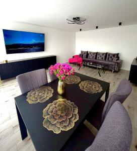 a living room with a table with flowers on it at Silver II in Świnoujście