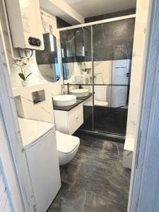 a bathroom with a toilet and two sinks and a shower at Silver II in Świnoujście
