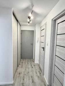 an empty hallway with white walls and wooden floors at Silver II in Świnoujście