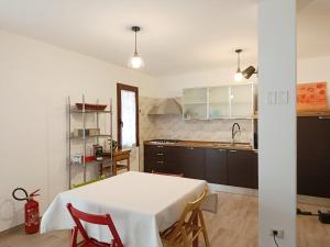 a kitchen with a white table and chairs in a room at Casa IS JANAS in San Sperate +4 photos