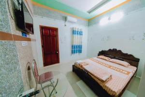 a bedroom with a bed and a chair in it at Gia Long Motel in Long Hai