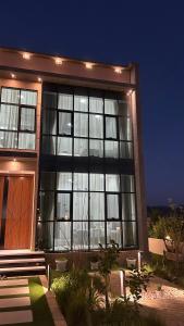 a large building with large windows at night at Rawnaq aljabal chalet in Qurayyah