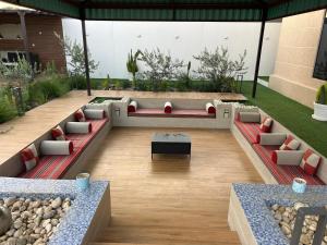 an outdoor patio with couches and a table at Rawnaq aljabal chalet in Qurayyah