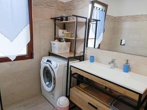 a bathroom with a washing machine and a sink at Casa IS JANAS in San Sperate