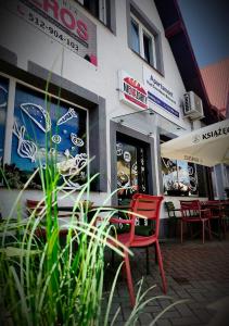 a red chair sitting in front of a restaurant at Apartamenty Nad Suwalskim Bulwarem in Suwałki