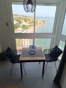 a table and chairs in a room with a view of the ocean at BEACH ALMIRANTE 9 MIJAS Marbella in Sitio de Calahonda