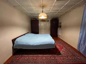 a bedroom with a bed in a room with a rug at Old House in Sheki