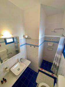 a bathroom with a sink and a toilet and a mirror at Villa Nefeli in Perissa +22 photos