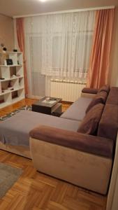 a bedroom with a large bed and a table at Apartman Nikola in Žarkovo