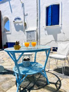 a blue table with two glasses of orange juice on it at Villa Nefeli in Perissa