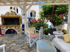 a patio with a fireplace and chairs and a couch at Villa Nefeli in Perissa