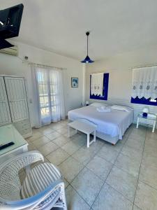 a bedroom with a bed and two chairs in it at Villa Nefeli in Perissa