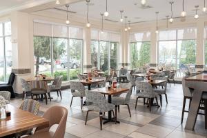a restaurant with tables and chairs and windows at Holiday Inn Effingham by IHG in Effingham