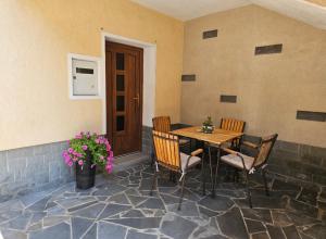 a patio with a table and chairs and flowers at Apartma Sofiora in Dekani