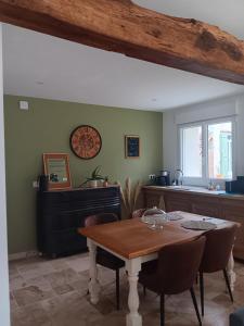 a dining room with a table and a kitchen at Ô Bois Jer'Home in Bois-Jérôme-Saint-Ouen