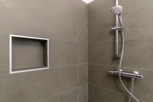 a shower with a shower head and a mirror at Altavista Aura in Molveno +28 photos