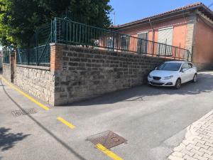 a white car parked next to a brick wall at Apartma Sofiora in Dekani