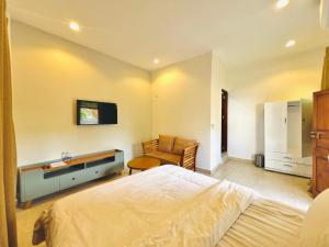 una camera da letto con un letto, una sedia e un divano di Panda Hostel a Zanzibar City