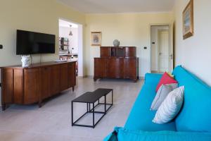 a living room with a blue couch and a flat screen tv at Agriturismo Agricola Cassiano in Morciano di Leuca