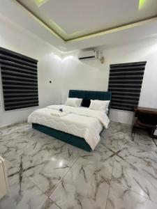 a bedroom with a large bed and a table at At Kora Apartment and Shortlets in Asaba
