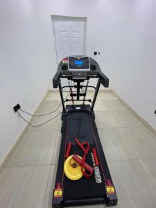 a treadmill with a pair of scissors on a cart at At Kora Apartment and Shortlets in Asaba