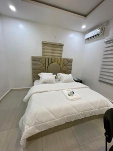 a bedroom with a large white bed in a room at At Kora Apartment and Shortlets in Asaba +2 photos