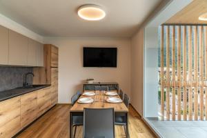 a kitchen and dining room with a wooden table and chairs at Altavista Aura in Molveno