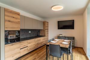 a kitchen with a table and chairs in a room at Altavista Aura in Molveno