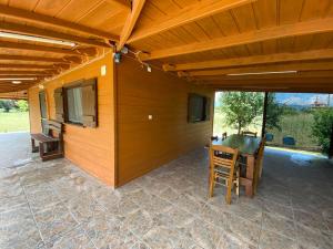 a patio with a wooden roof with a table and chairs at Garden Villa in Stavros