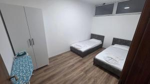 a small room with two beds and a closet at Art Apartment in Prizren