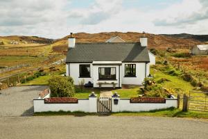 a white house with a fence in front of it at Taigh Tuaram in Carloway